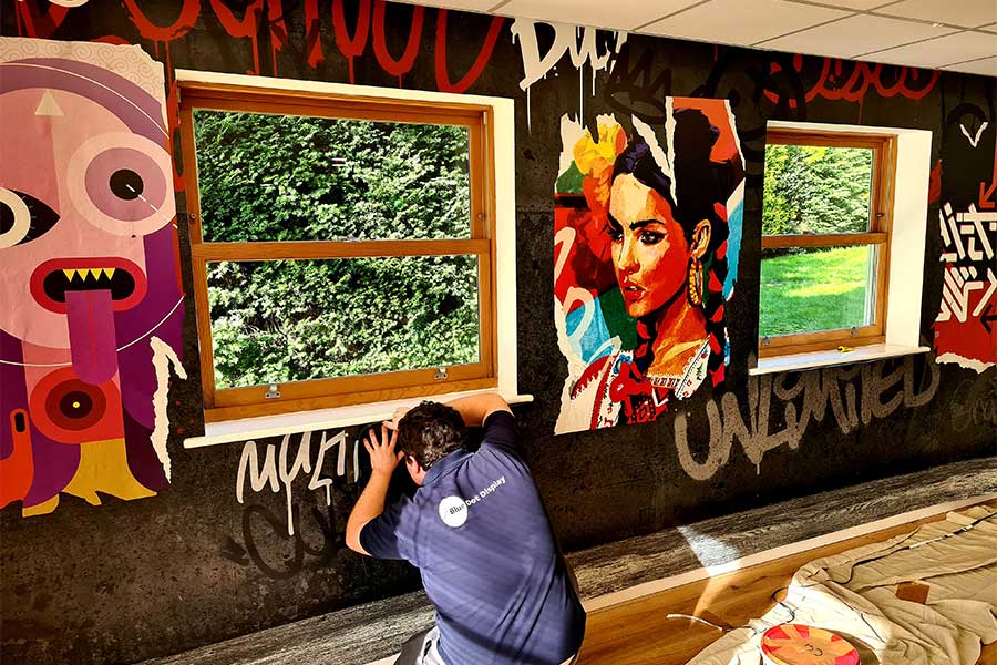 James from Bluedot Display installing an art inspired full wall wrap graphics to an office interior